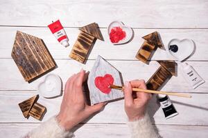 vrouw tekening hart Aan houten huis, bouwen, stap door stap instructies hoe naar maken decor voor valentijnskaarten, moeders dag foto