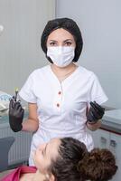 tandarts onderzoeken geduldig tanden in tandheelkundig kliniek. tandheelkunde en gezondheidszorg. tandarts Holding tandheelkundig gereedschap in haar handen. foto