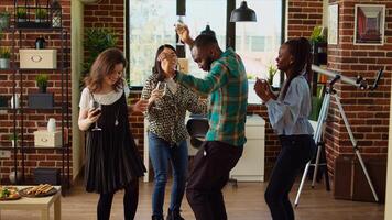 multiraciaal school- collega's organiserende appartement partij, enthousiast dansen naar elektronisch muziek. glimlachen vrienden genieten van tijd uitgegeven samen, kapot maken in dynamisch dans beweegt foto