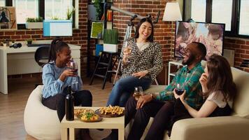 verschillend groep vrienden vieren Aziatisch vrouw verjaardag, drinken alcoholisch dranken en aan het eten voorgerechten in leven kamer. gelukkig gasten lachend en bespreken na schenken gastheer presenteert foto