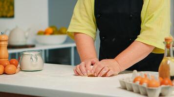 vrouw handen kneden deeg Aan tafel, voorbereidingen treffen gebakje en keuken producten. gepensioneerd ouderen bakker met bot menging ingrediënten met tarwe meel voor bakken eigengemaakt taart en brood foto