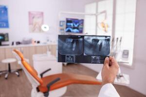 orthodontist radioloog dokter Holding tanden kaak chirurgie radiografie geduldig planning gezondheidszorg behandeling. specialist radioloog werken in stomatologie tandheelkunde ziekenhuis kantoor kamer foto