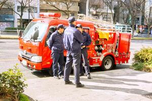 Osaka stad, Japan, 2023 - brandweerlieden en brand vrachtauto van Osaka stad geparkeerd Bij stad langs de weg en zijn bereid naar omgaan met ieder brand dat kan gebeuren Bij ieder tijd. foto