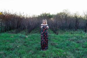 de dame Aan de achtergrond van droog bomen. vrouw in een jurk. foto