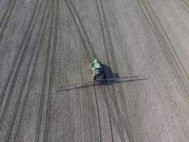 trekker met scharnierend systeem van sproeien pesticiden. bemesting met een tractor, in de het formulier van een aërosol, Aan de veld- van winter tarwe. foto