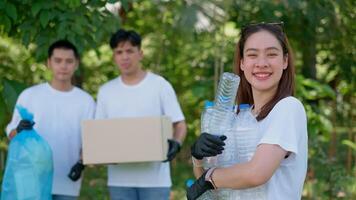 gelukkig jong Aziatisch studenten verschillend vrijwilligers met vuilnis Tassen schoonmaak Oppervlakte in de park, de concept van milieu behoud Aan wereld milieu dag, recyclen, liefdadigheid voor duurzaamheid. foto