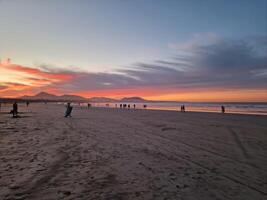 zonsondergang Aan famara strand Aan Lanzarote eiland foto