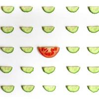 herhalend patroon van gesneden halve cirkels van verse rauwe groentekomkommers voor salade en tomaat foto