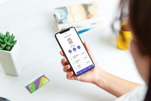 vrouw voegt toe credit kaart en account Aan een FinTech onderhoud app, weergegeven Aan een modern smartphone. met de account en een transactie lijst voor naadloos financieel beheer foto