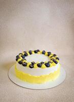 verjaardag wit en geel taart met bosbessen Aan een wit bord Aan een licht achtergrond foto