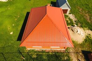 huis met een oranje dak gemaakt van metaal, top visie. metalen profiel geschilderd gegolfd Aan de dak. foto