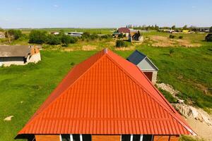 huis met een oranje dak gemaakt van metaal, top visie. metalen profiel geschilderd gegolfd Aan de dak. foto