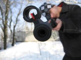 Mens met een lucht geweer- in een winter park. foto