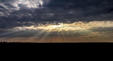 zon stralen breken door cumulus wolken. hemels landschap foto