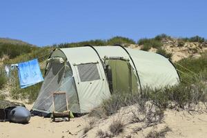 toerist vouwen tenten tussen kust- vegetatie. de tent is modern. foto