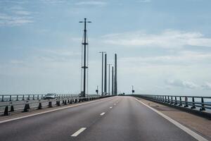 ervaring de modern oresund brug met een Doorzichtig lucht en sereen zee visie. foto