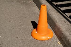 een verkeer oranje ijshoorntje is gebruikt net zo een barrière gedurende weg bouw werk foto