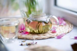 groen thee in een glas theepot Aan de vensterbank. foto