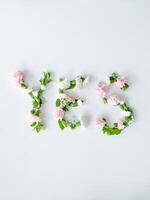 de woord Ja van bloemen Aan een wit achtergrond. foto