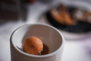 heerlijk koffie breken met een donut in een wit kop Aan een tafelblad. foto