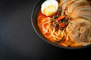 ramen noodles pittige tomyum soep met geroosterd varkensvlees foto