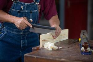 timmerman werken met uitrusting Aan houten tafel. timmerman werken Aan houtbewerking machines in timmerwerk winkel. Mens werken in een timmerwerk winkel. foto