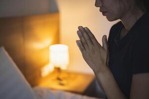 een vrouw vouwde haar handen, bad om zegeningen en bad tot god. bidden voor spirituele overtuigingen. de kracht van hoop of liefde en loyaliteit. geloof in goedheid. foto