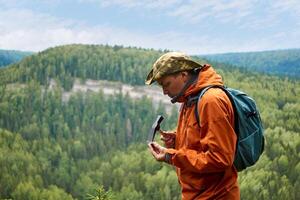 mannetje geoloog Aan een expeditie onderzoekt een steen voor hardheid met een hamer foto