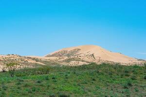 halfdroog landschap in de nabijheid van de sarykum zand duin foto