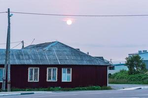 bewolkt zonsondergang over- een dorp huis foto