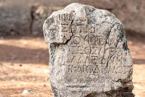 achtergrond - half gewist antiek opschrift Aan een steen tussen de ruïnes van de oude stad van faselis, kalkoen foto