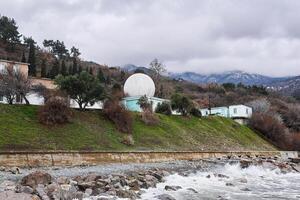 klein observatorium met een wit geodetisch koepel Aan de kust foto