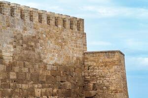 kantelen van een middeleeuws vesting tegen de lucht, naryn-kala citadel in debent foto