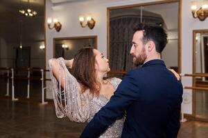 Mens en vrouw dansen expressief partner dans in leeg balzaal foto