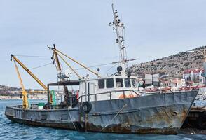 klein oud visvangst schip seiner afgemeerd in de haven foto