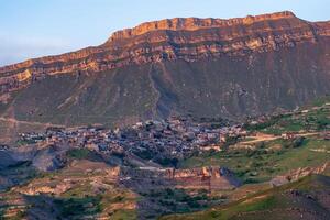 avond visie van de berg dorp van chok in dagestan Aan de helling van een enorm vallei foto