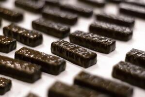 gesmolten chocola gegoten in een dienblad in een banketbakkerij fabriek, detailopname foto