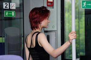 jong vrouw is voorbereidingen treffen naar krijgen uit Bij een hou op van een buitenwijk trein auto foto