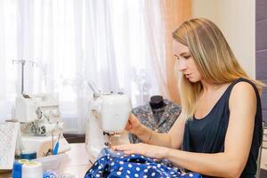 vrouw kleermaker maakt naad Aan naaien machine Bij huis foto