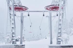 bovenste station van de ski optillen Aan een met sneeuw bedekt heuveltop tussen ijzig bomen foto