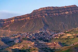 avond visie van de berg dorp van chok in dagestan Aan de helling van een enorm vallei foto