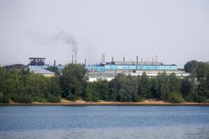 industrieel landschap met een fabriek Aan de banken van de rivier- foto