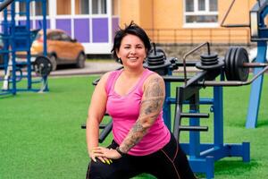 gespierd mollig vrouw het uitvoeren van opdrachten Aan de sport- grond foto