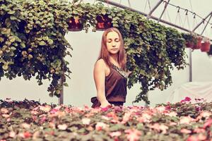 vrouw in jurk tussen sier- planten in sepia tonen foto