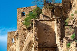 ruïnes van steen huizen gehecht naar de rots in de ontvolkt dorp van gamsutl in dagestan foto