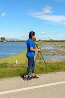 latina vrouw, actief individu met wandelen polen De volgende naar een water lichaam Aan een zonnig dag, spaans latina vrouw wandelen met trekking polen in de ebro delta natuurlijk park, tarragona, Catalonië, Spanje foto