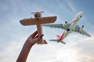 kind Holding een houten vliegtuig model- hoog in de lucht foto