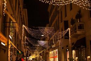 wazig achtergrond van Kerstmis straat lichten met mensen wandelen met boodschappen doen Tassen in Milaan, Italië 2.12.2023 foto