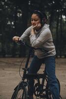 gelukkig Aziatisch jong vrouw wandelen en rijden fiets in park, straat stad haar glimlachen gebruik makend van fiets van vervoer, eco vriendelijk, mensen levensstijl concept. foto