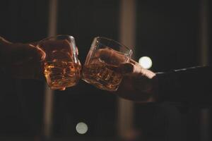 viering nacht, gieten whisky in een glas. geven naar vrienden wie komen naar vieren foto